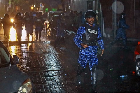 A Maldives policeman charges with baton towards protesters after the government declared a 15-day state of emergency. (Photo | AP)