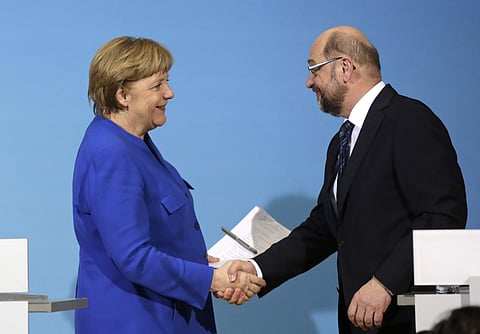 German Chancellor Angela Merkel shakes hand with Social Democratic Party Chairman Martin Schulz (Photo | AP)