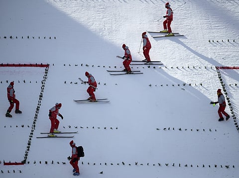 Workers groom the course between practice runs for the men's ski jumping competition in the 2018 Winter Olympics at the Alpensia Ski Jumping Center in Pyeongchang, South Korea. | AP
