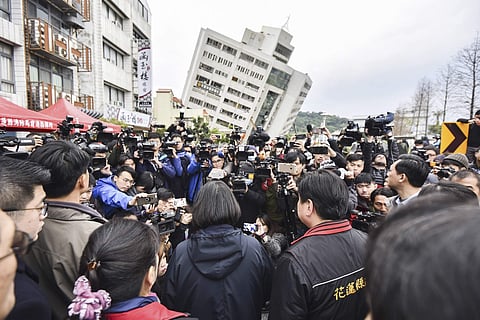 Taiwan's President Tsai Ing-wen, center back-facing, is briefed at the site of a collapsed building from an earthquake in Hualien. (Photo | AP)