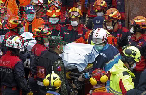Rescuers carry the body of a victim recovered from a collapsed building | AP