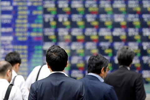 People walk past an electronic stock quotation board outside a brokerage in Tokyo, Japan. (File | Reuters)