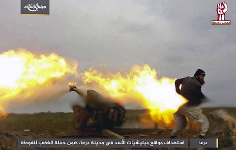 A fighter with the Army of Islam rebel group firing artillery during clashes with government forces in the southern province of Daraa, Syria. | AP
