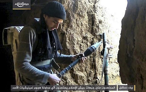 A fighter with the Army of Islam rebel group, as he prepares a rocket propelled grenade in the suburbs of the Syrian capital Damascus. | AP