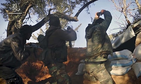 Fighters with Failaq al-Rahman firing their weapons during clashes with government forces in the suburbs of the Syrian capital Damascus. | AP