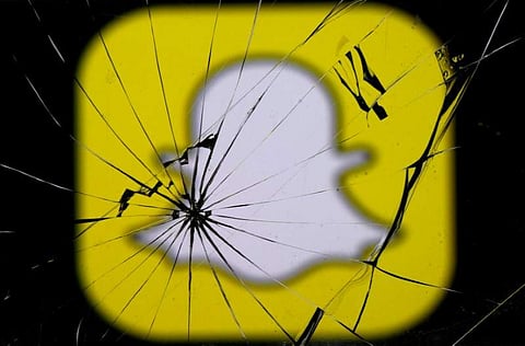 Snapchat logo is seen through broken glass in this illustration picture, May 11, 2017. (REUTERS)