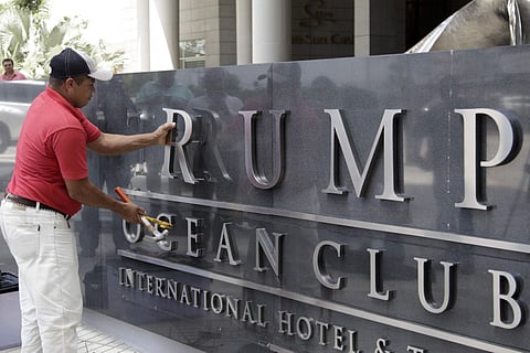 A man removes the word Trump, off a marquee outside the Trump Ocean Club International Hotel and Tower in Panama City. (Photo |AP)