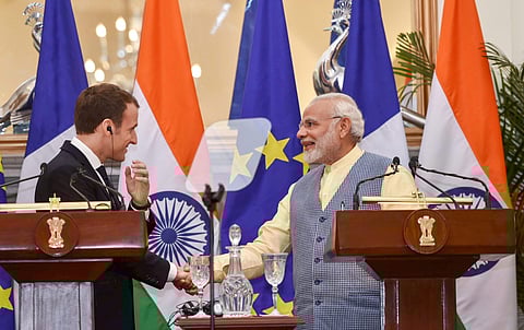 Prime Minister Narendra Modi shakes hands with French President Emmanuel Macron during their joint press conference at Hyderabad House in New Delhi on Saturday. | PTI