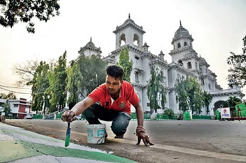 A worker paints the surroundings of TS Legislative Assembly premises ahead of the Budget session which begins on Monday. As many as 2,000 security forces personnel including additional forces will maintain security | R Satish Babu