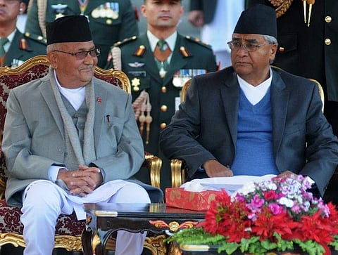 FILE: Nepal's newly-elected Prime Minister KP Sharma Oli (L) and outgoing Prime Minister Sher Bahadur Deuba (R) look on during the swearing-in ceremony at the President's House in Kathmandu. | AFP