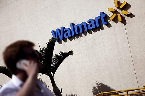 A man talks on his mobile phone in front of a Wal-Mart store in Sao Paulo, Brazil | Reuters