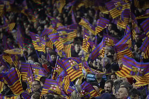Barcelona fans wave flags during the Champions League round of sixteen second leg soccer match against Chelsea. | AP