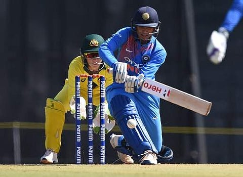 Indian cricketer Smriti Mandhana plays a shot as Australian wicketkeeper Alyssa Healy looks on during the first cricket match of the women's Twenty 20 (T20) Tri-Series between India and Australia at the Brabourne stadium in Mumbai on March 22, 2018. | AFP