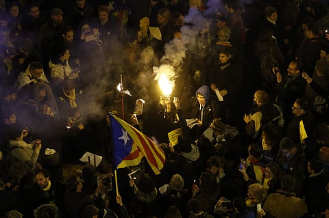 People burn a photo of Spain's Prime Minister Mariano Rajoy during a protest over the jailing of Catalan politicians. (Photo | AP)