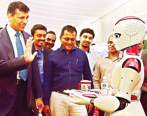 Former RBI Governor Raghuram Rajan is surprised as a robot welcomes him to the Maker Village stall at the #Future summit in Kochi on Friday |  Albin Mathew