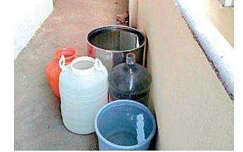Five uncovered containers stocked with water along a narrow corridor at Fatima Girls High School on Coles Road in Fraser Town
