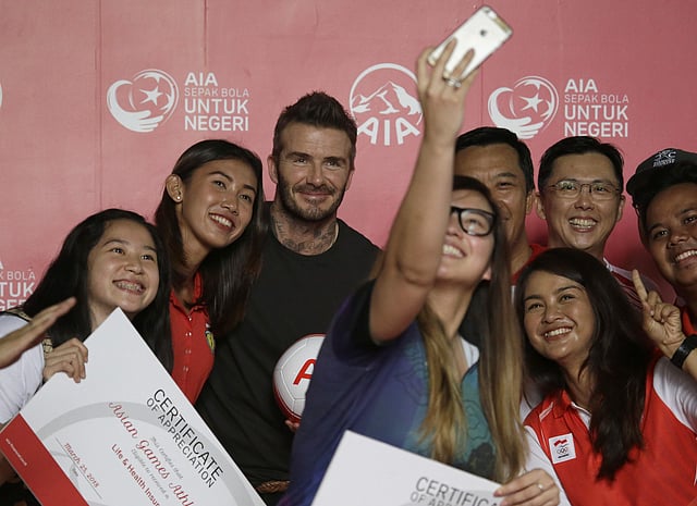 Indonesian athletes pose for a selfie with former British soccer star David Beckham during a promotional event in Jakarta. | AP