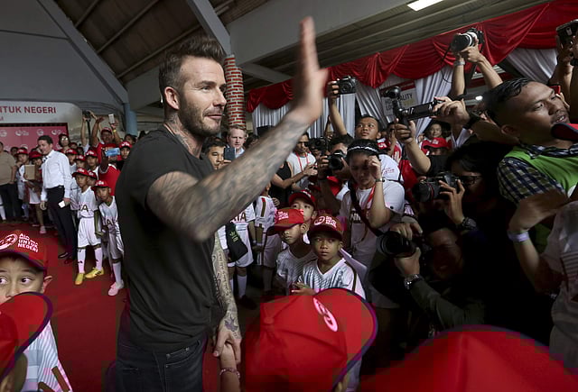Former British soccer star David Beckham, center, gestures, during a promotional event in Jakarta. | AP