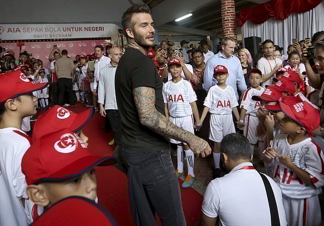 Former British soccer star David Beckham, centre, smiles during a promotional event in Jakarta. | AP