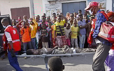 Medical workers carry away a man who was severely injured in a car bomb explosion near the parliament building in the capital Mogadishu. | AP