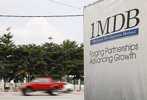 Traffic passes a 1Malaysia Development Berhad (1MDB) billboard at the Tun Razak Exchange development in Kuala Lumpur. (Photo | Reuters)