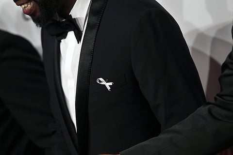 A guest wears a white ribbon as he arrives at the 43rd Cesar Film Awards ceremony. (Photo | AP)