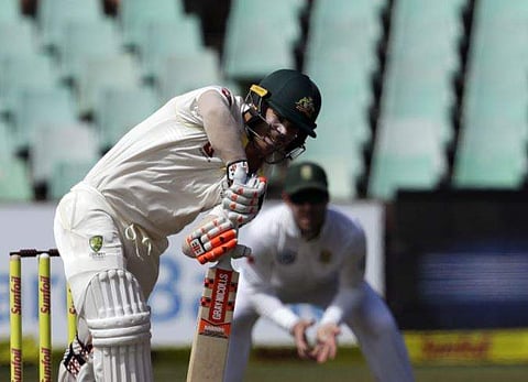 Australia's batsman David Warner, front, plays a delivery as South Africa's wicketkeeper Quinton de Kock watches on during day three of the first cricket test match. | AP
