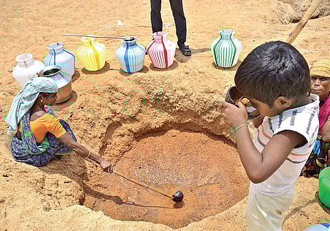 A woman drawing water from a waterhole in the Vaigai riverbed near Sevoor village near Ramanathapuram | Alagu