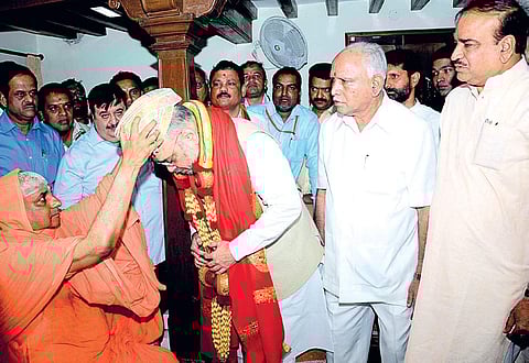 Shivarathri Deshikendra Swamiji of Suttur Mutt presenting a Mysuru peta to BJP chief Amit Shah in Mysuru on Friday. Party leaders BS Yeddyurappa, C T Ravi and Anath Kumar look on| Udayshankar S
