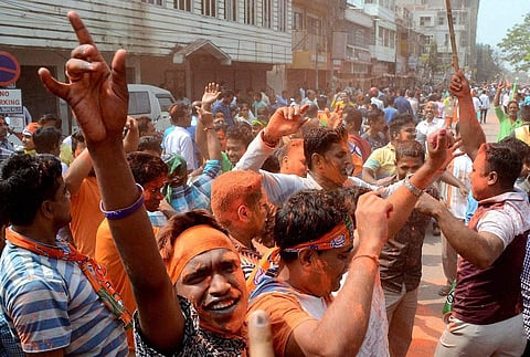BJP supporters smear colors on each other to celebrate BJP's win which brought down 25 years of CPI-M government rule after Tripura Assembly election results were announced in Agartala. (PTI)