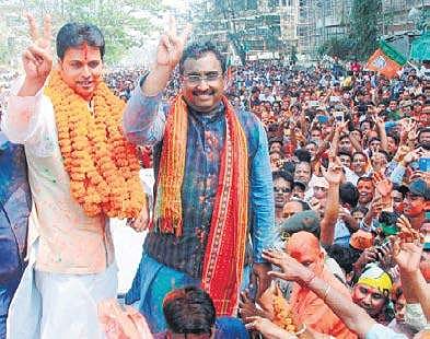 BJP leaders Ram Madhav and Biplab Kumar Deb flash the victory sign in Agartala on Saturday. (PTI)