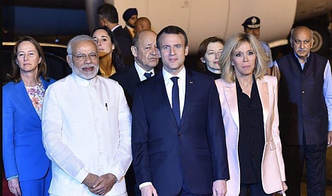 Prime Minister Narendra Modi with French President Emmanuel Macron and his wife Brigitte Macron upon their arrival at AFS Palam in New Delhi on Friday. - PTI