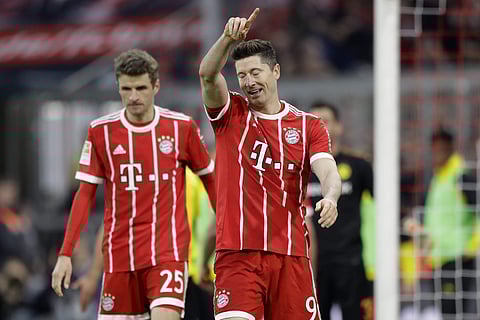 Bayern's Robert Lewandowski celebrates after scoring his side's fourth goal during the German Bundesliga soccer match between FC Bayern Munich and Borussia Dortmund in Munich, Germany, Saturday, March 31, 2018. | AP