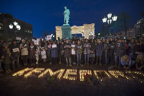 People stand in front of the word Kemerovo, made up of candles, to commemorate the victims of Sunday's fire in a shopping mall in the Siberian city of Kemerovo, in Pushkin Square, with a Pushkin monument in the background, in Moscow. | AP