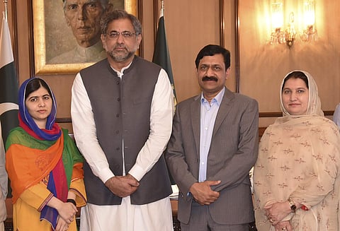 In this photo released by the Press Information Department, Pakistani Nobel Peace Prize winner Malala Yousafzai, left, and her parents pose for a photograph with Shahid Khaqan Abbasi, second from left, Prime Minister of Pakistan in Islamabad. | AP