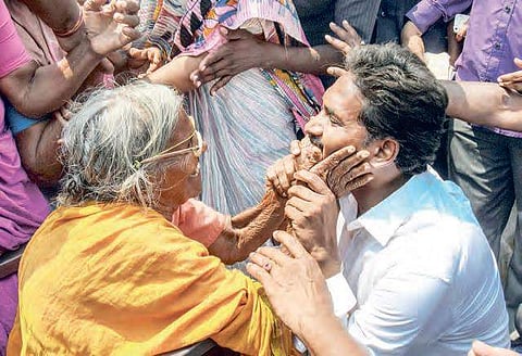 YSRC chief Jagan Mohan Reddy interacts with an aged woman during his padayatra in Guntur district. | EPS