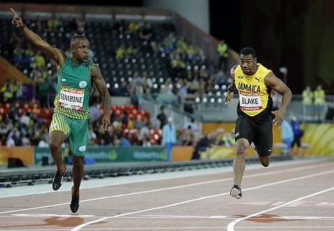 South Africa's Akani Simbine (L) celebrates finishing ahead of Jamaica's Yohan Blake in the men's 100m final at Carrara Stadium (File | AP)