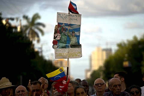 Cubans of every generation are watching this week as Raul Castro leaves the presidency as part of a broader handoff to a group of younger leaders. In this image, People hold an image of Cuba's late leader Fidel Castro and his brother, current President Raul Castro, during an event in Havana, Cuba, Monday, April 16, 2018. (AP)