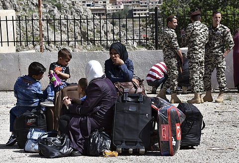 Displaced people who fled Syrian war sit on their belongings near the Lebanese-Syrian border as they prepare to return to Syria (File Photo | AP)