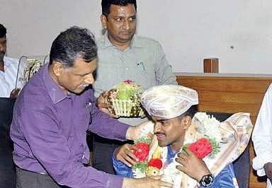 Gururaj Poojari being honoured by Udupi ZP CEO Shivanand Kapasi   in Udupi on Thursday I Express