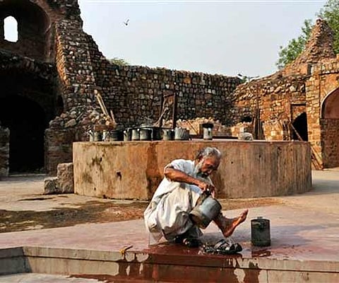 A man washes his feet with the water drawn from a well on a hot summer day at the Purana Qila or Old Fort monument in New Delhi. | AP File Photo
