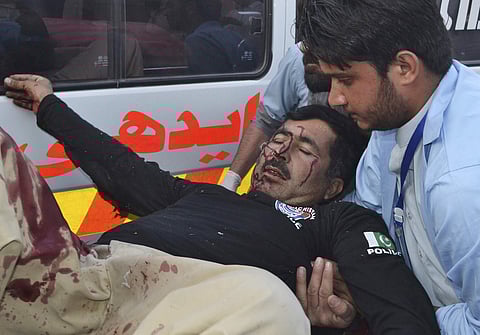 Pakistani staff help an injured police officer shifting to a hospital in Quetta, Pakistan, Tuesday, April 24, 2018. | Associated Press
