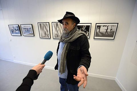 In this file photo taken on November 28, 2013 in Paris, Magnum photographer Abbas answers journalists' questions in front of some of his pictures, displayed at the Islamic Institute of Culture on its inauguration day. | AFP
