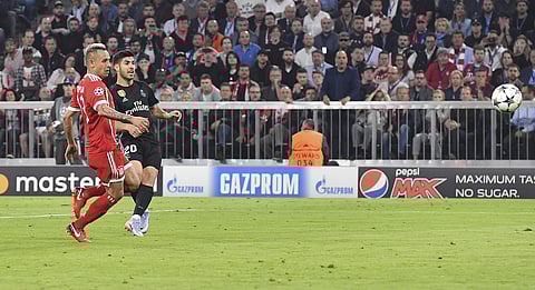 Real Madrid's Marco Asensio, right, scores his side's winning goal against Bayern's Rafinha during the semifinal first leg soccer match between FC Bayern Munich and Real Madrid at the Allianz Arena stadium in Munich, Germany, Wednesday, April 25, 2018. | 