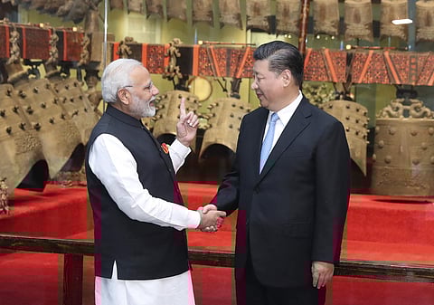 In this photo released by China's Xinhua News Agency, Indian Prime Minister Narendra Modi, left, shakes hands with Chinese President Xi Jinping as they visit an exhibition of cultural relics at the Hubei Provincial Museum in Wuhan in central China's Hubei