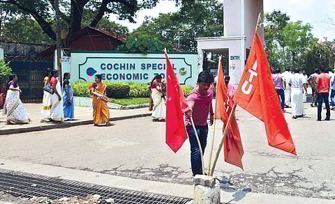 They were planning to go to Munnar by bus, unaware of the all-India trade union strike, (Right) Trade union members protesting outside the Special Economic Zone | Albin Mathew