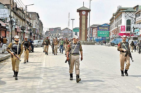 Police personnel stand guard at Lal Chowk in Srinagar on Monday during a shutdown called by separatists in protest against the killing of militants and civilians in encounters on Sunday | PTI