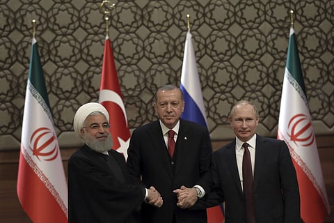 Iran's President Hassan Rouhani, left, Russia's President Vladimir Putin, right, and Turkey's President Recep Tayyip Erdogan join hands after a joint press conference in Ankara, Turkey, Wednesday, April 4, 2018. (Photo | AP)