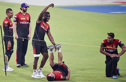 Kolkata Knight Riders cricketer Andre Russell share a lighter moment with Piyush Chawla as other teammates look on during their training session ahead of the Indian Premier League match against Royal Challengers Bangalore at Eden Garden. | PTI