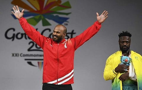 Sathish Kumar Sivalingam  (L) celebrates after winning the gold medal in the men's 77kg weightlifting event as Australia's bronze medallist Francois Etoundi (R) looks on. (Photo | AFP)